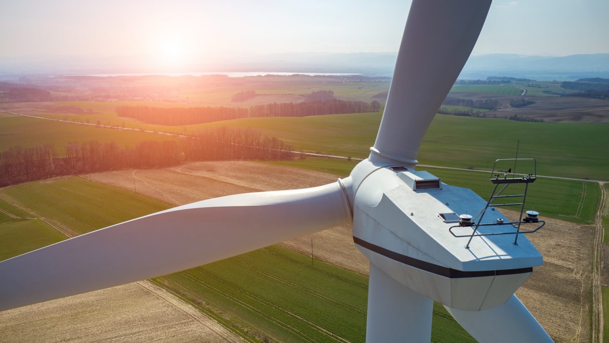 Beautiful sunset above the windmills on the field