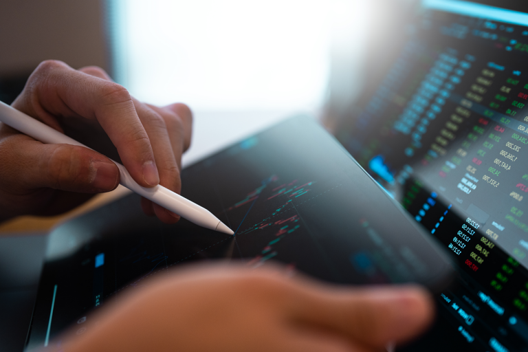 A person analysing charts on a tablet using a tablet pen