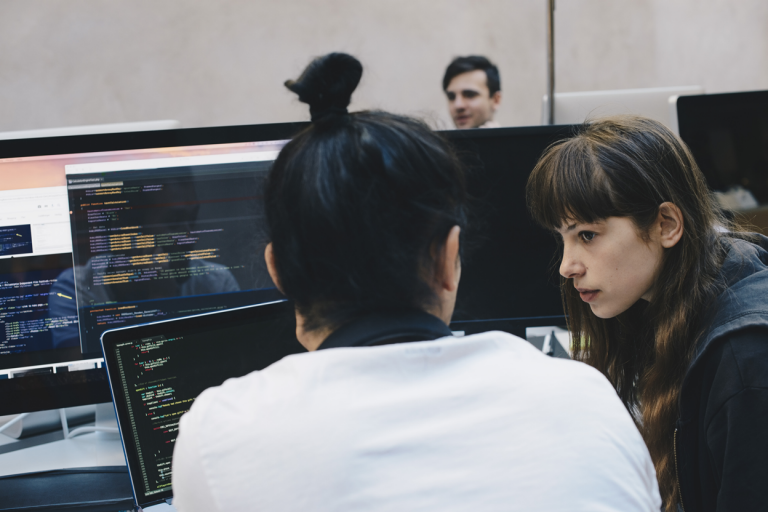 Two people talking to each other while discussing some information present on a laptop screen