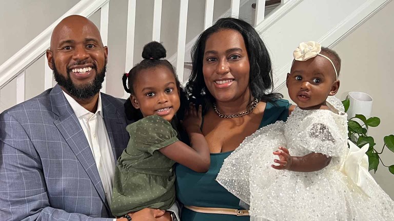 Employee and family smiling together indoors.