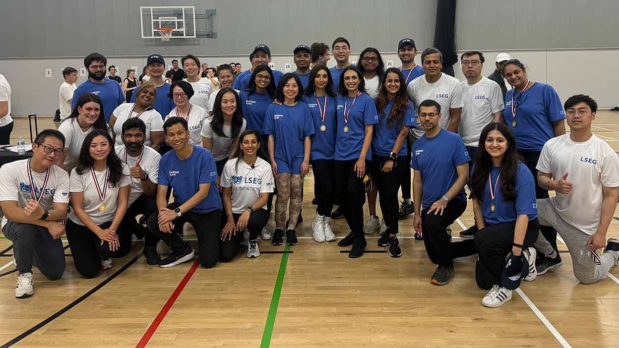 LSEG volunteers in LSEG shirts posing on a sports court supporting Sportsinspired Charity.
