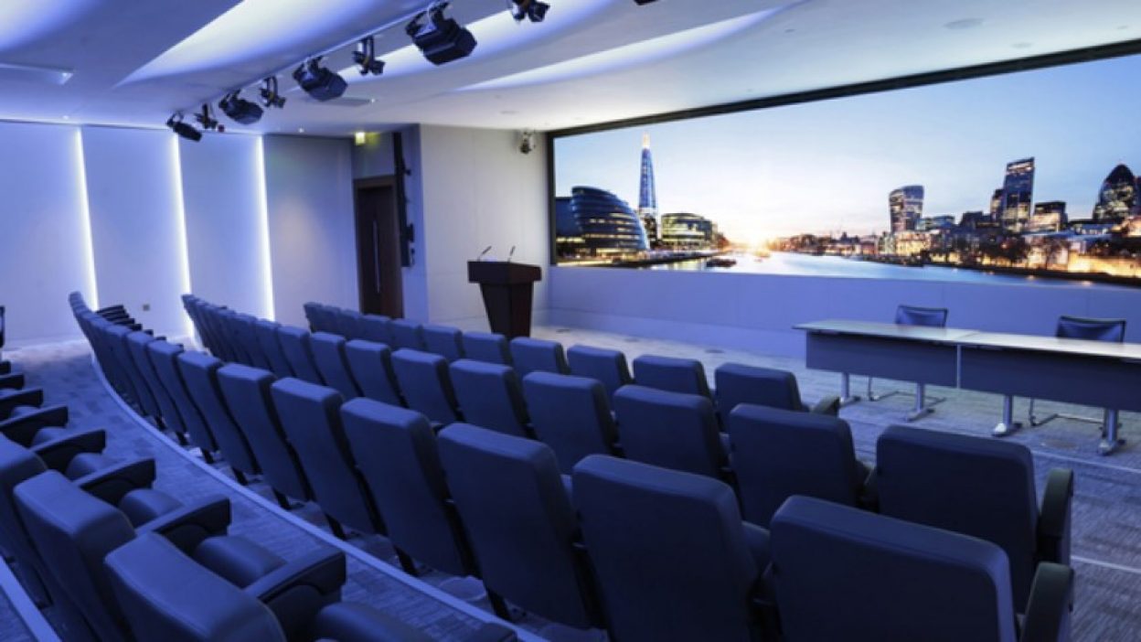 Theatre (our tiered auditorium) with the London skyline as the backdrop. Lectern to the left hand side and top table to the right hand side set for two speakers.
